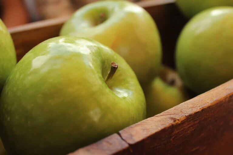 green apples piled into a box