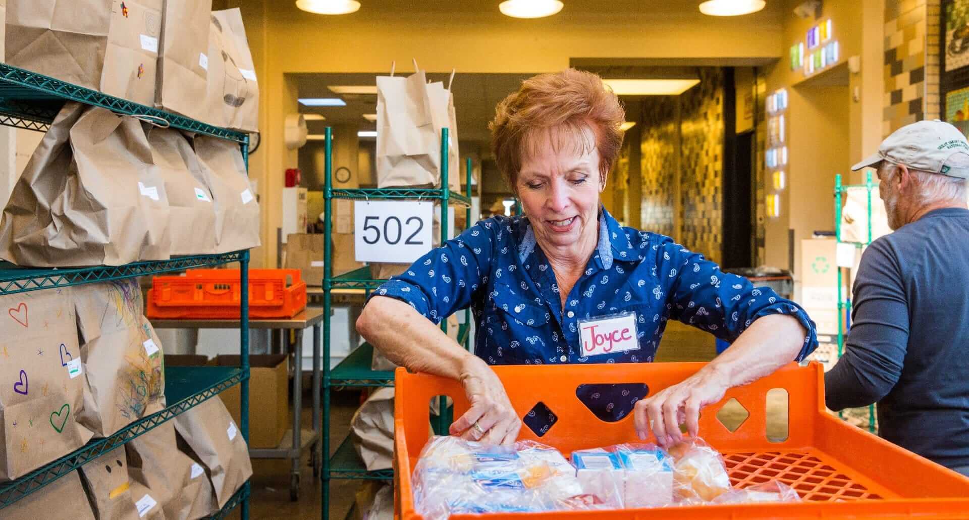 A volunteer packs meal bags for Project Angel Heart clients