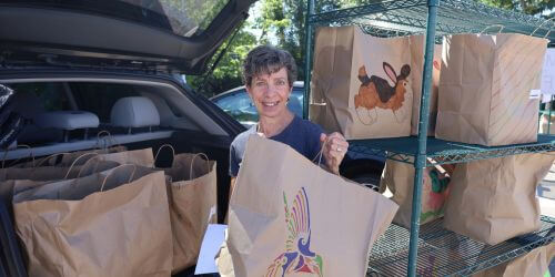 Theresa loading meal bags into her car