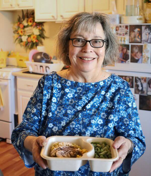 Client Stephanie holding a Project Angel Heart meal