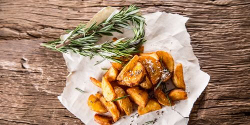 roasted potatoes on a table with fresh rosemary