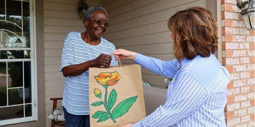 Client Merrissere receiving Project Angel Heart meal bag