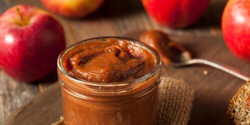 Apple butter and apple on table