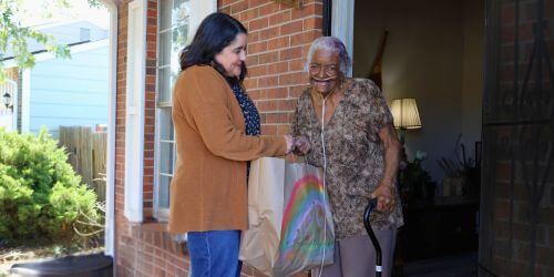 Volunteer bringing meal bag to client
